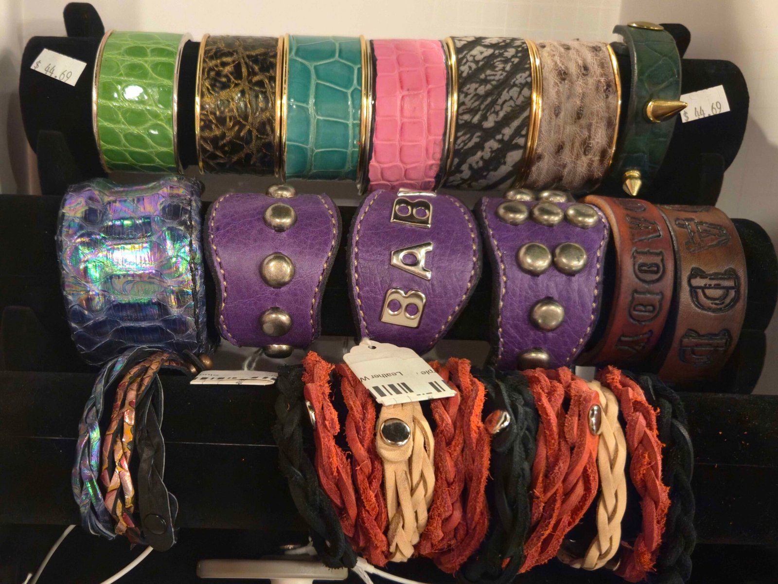 Colorful leather bracelets and cuffs with metallic accents, showcasing artisan craftsmanship, available at W.E.L.P.